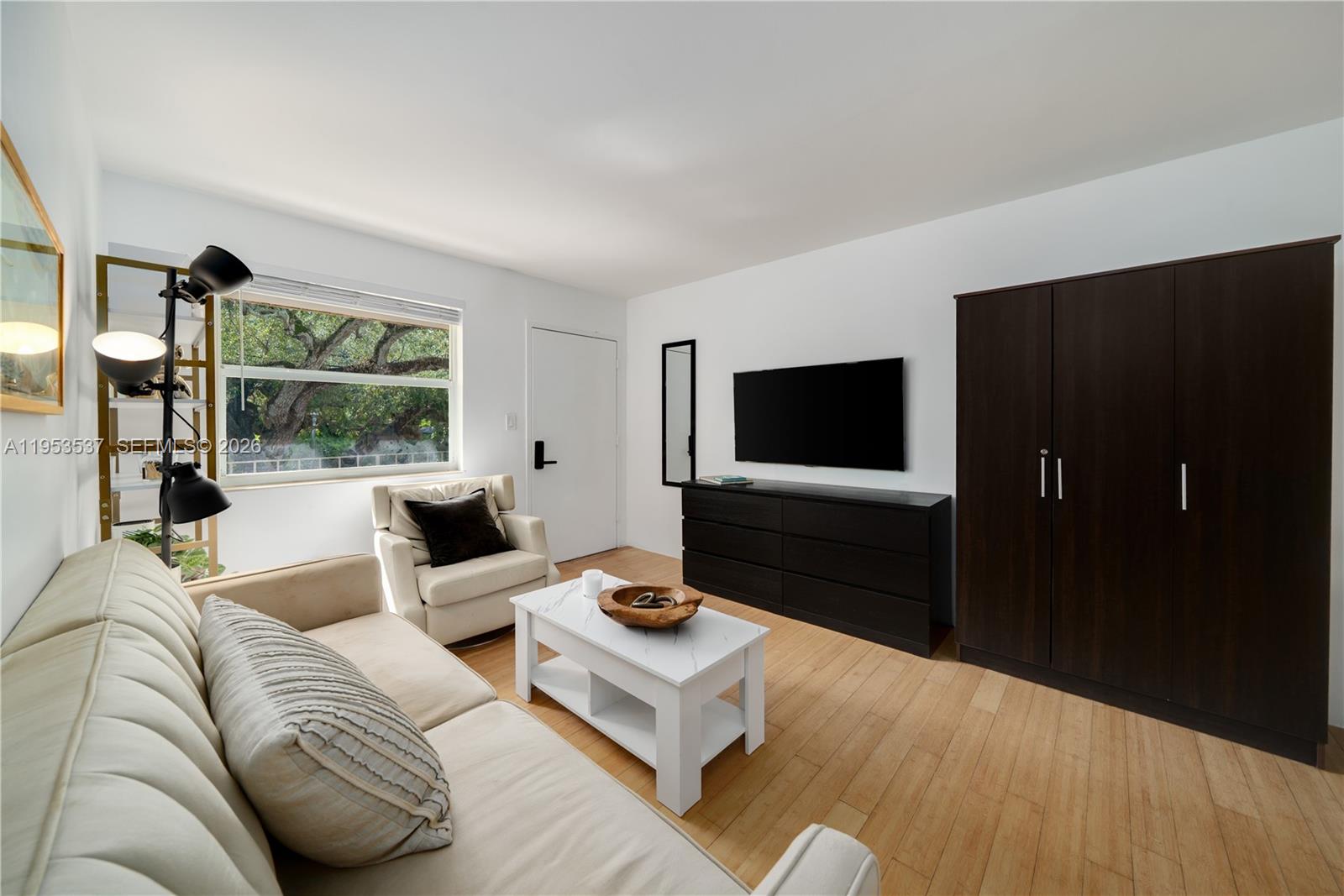 651 Northeast 60th Street, Unit 25 Miami, FL 33137 - Photo 8 of 23 a living room with furniture and a flat screen tv