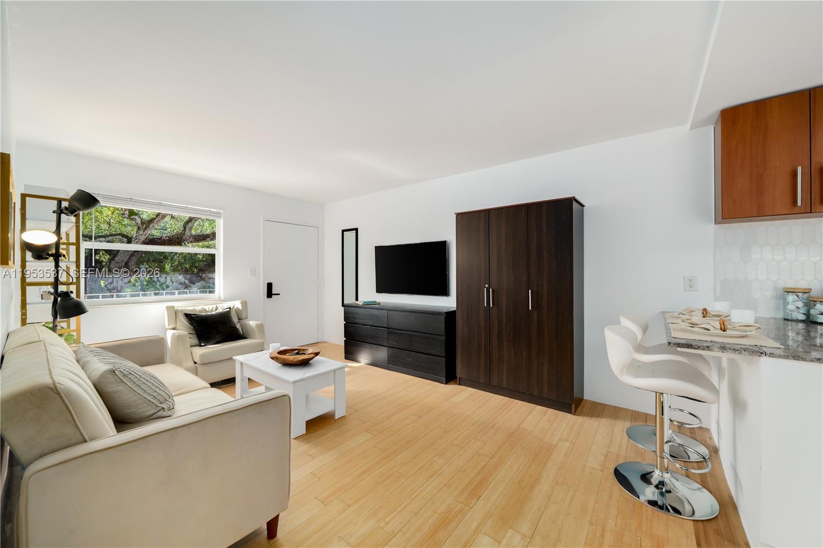 651 Northeast 60th Street, Unit 25 Miami, FL 33137 - Photo 9 of 23 a living room with furniture and a flat screen tv
