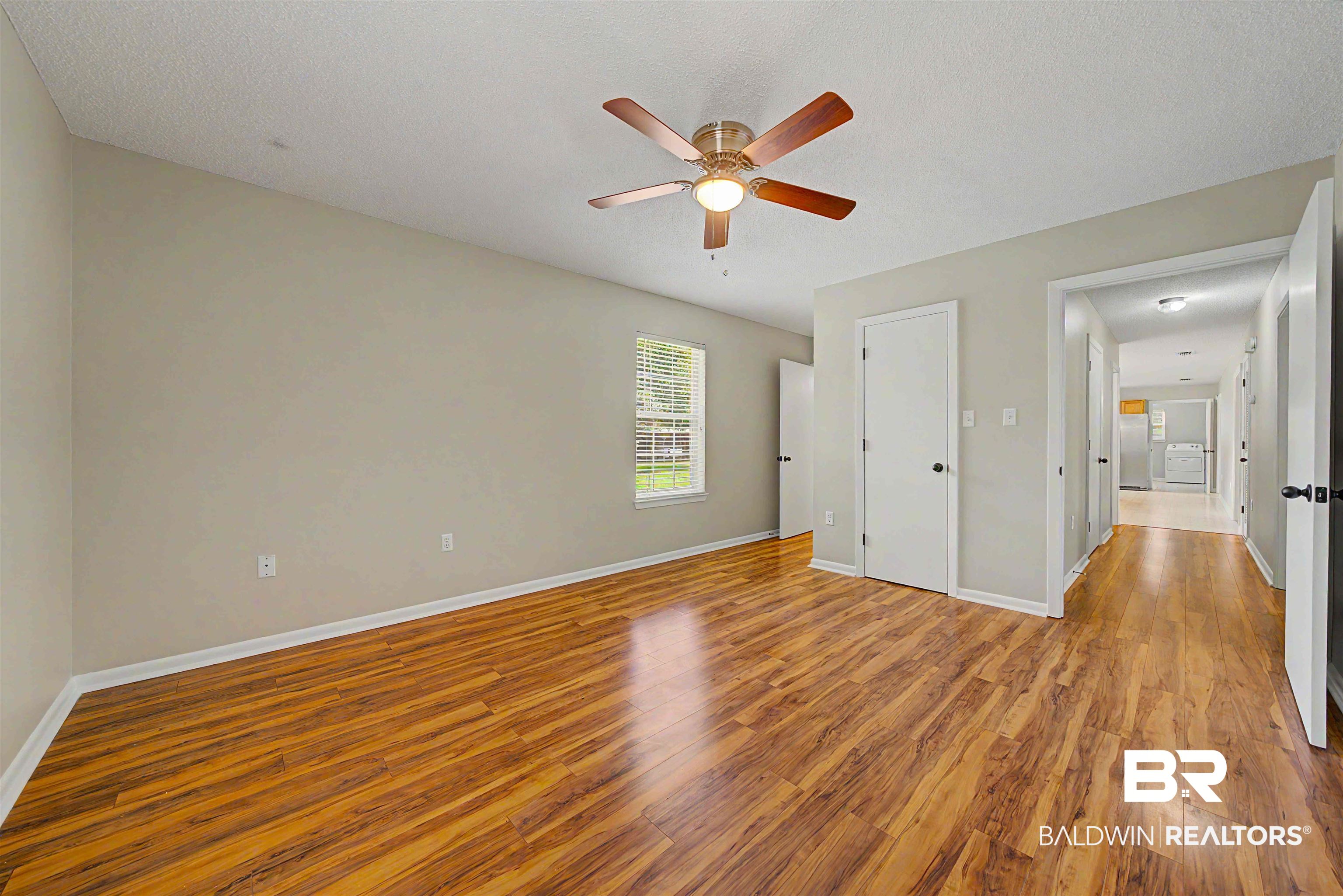 22963 Highway 98 Foley, AL 36535 - Photo 20 of 52 Spacious room featuring wood-finish flooring, a ceiling fan with integrated lighting, and a window with blinds