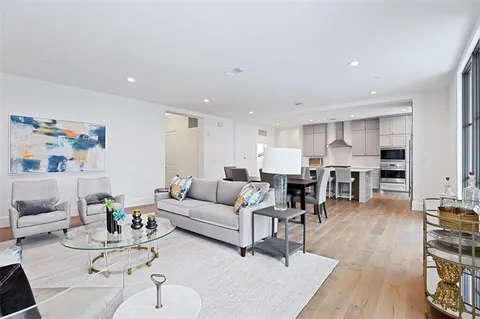 a living room with furniture and view of kitchen