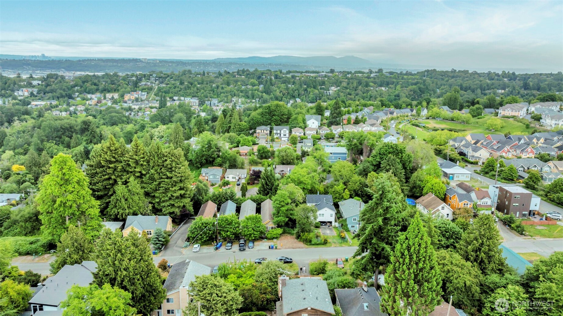 5630 32nd Avenue Southwest Seattle, WA 98126 - Photo 19 of 21 an aerial view of a city with lots of residential buildings and mountain view in back