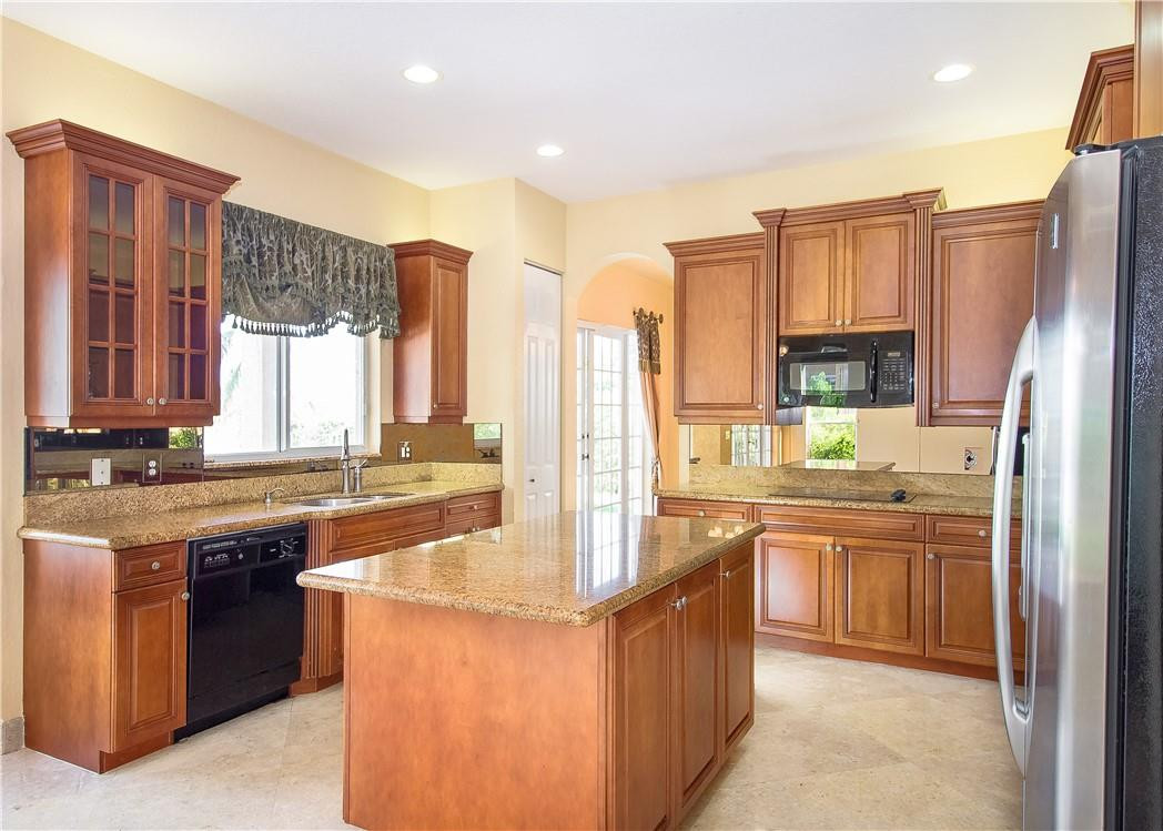 19471 Southwest 39th Street Miramar, FL 33029 - Photo 31 of 50 a kitchen with stainless steel appliances granite countertop a stove top oven a refrigerator a sink and dishwasher
