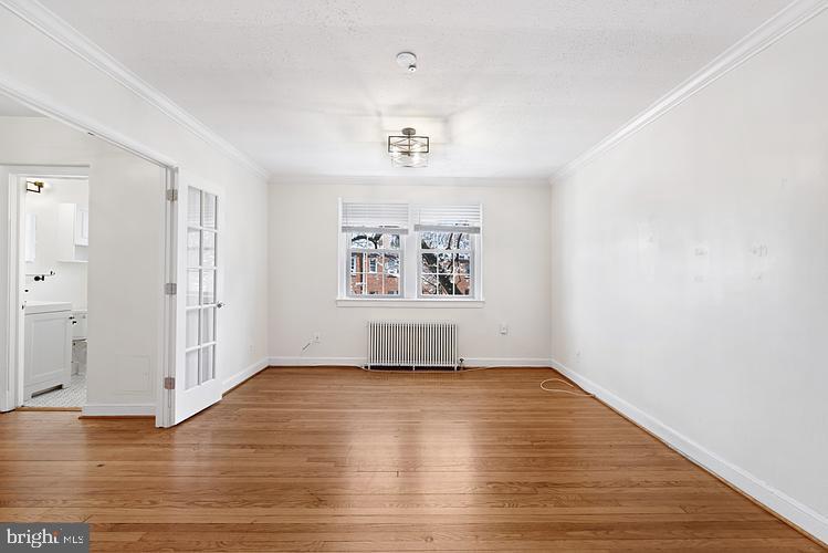 3925 Davis Place Northwest, Unit 206 Washington, DC 20007 - Photo 5 of 26 an empty room with wooden floor and windows