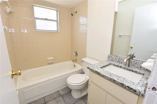 a bathroom with a granite countertop sink mirror vanity and toilet