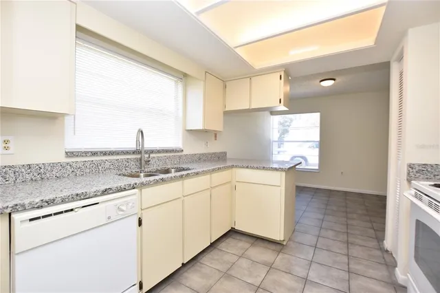 a kitchen with granite countertop a sink and a stove