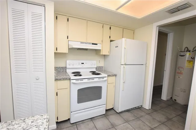 a white refrigerator freezer and a stove sitting inside of a kitchen