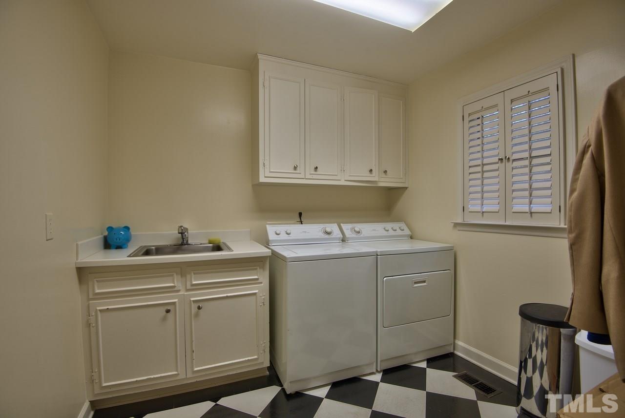 3916 St Marks Road Durham, NC 27707 - Photo 10 of 25 At the end of the kitchen with shelves and cabinets and a view of the back yard.