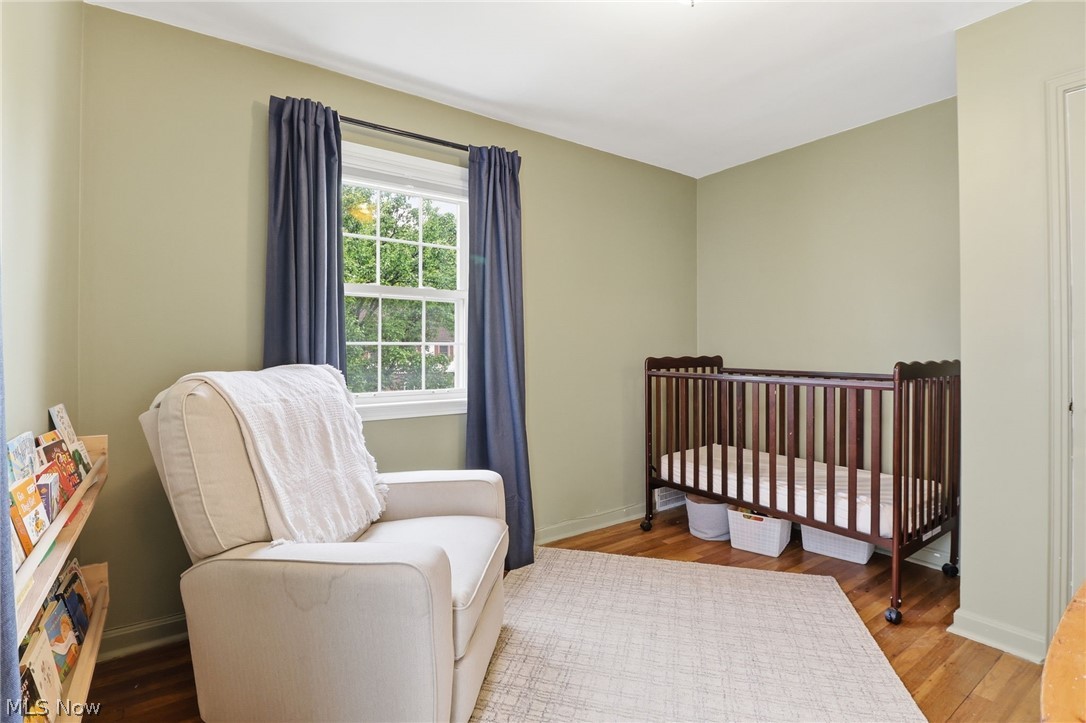 3713 Winchell Road Shaker Heights, OH 44122 - Photo 21 of 38 Room featuring wood-finish flooring, light green wall paint, and a window with white sashes
