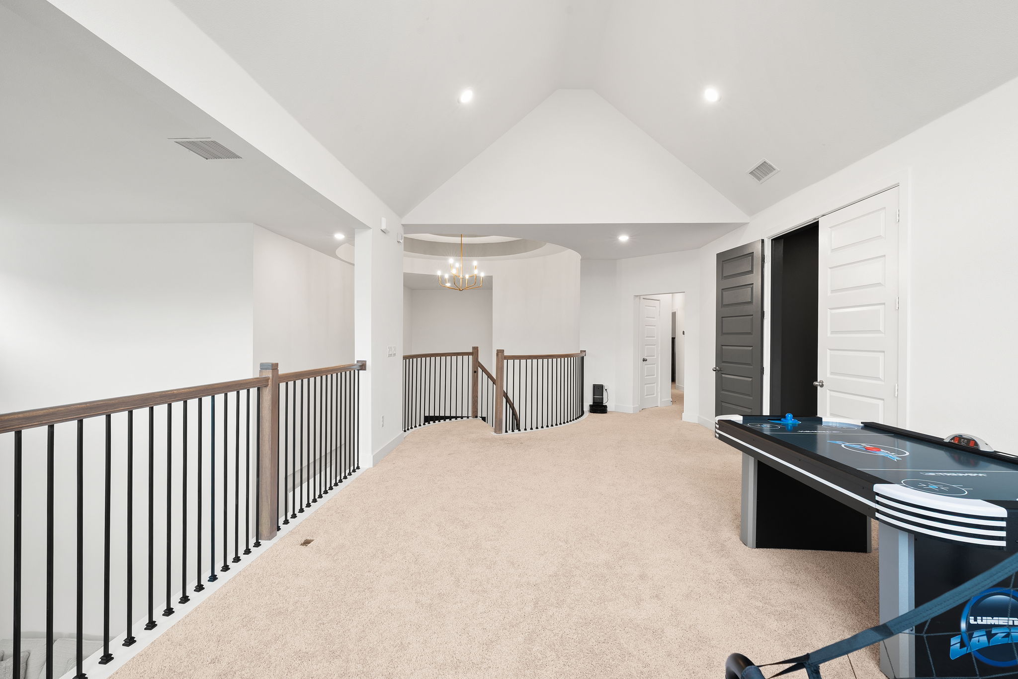 515 Watershield Cove Georgetown, TX 78633 - Photo 25 of 40 A spacious upper-level living area offers vaulted ceilings and soft carpeting, ideal for a flexible recreational space.