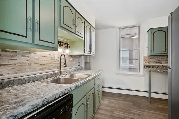 a kitchen with stainless steel appliances granite countertop a refrigerator a sink and cabinets