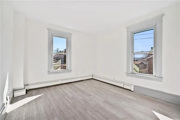 an empty room with wooden floor and white walls