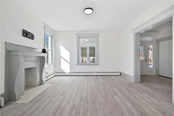 an empty room with wooden floor and a chair