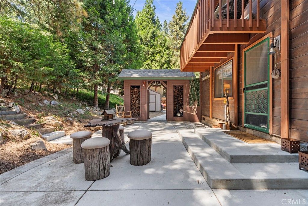 116 Pine Ridge Road Crestline, CA 92325 - Photo 27 of 35 a view of a patio with dining table and chairs and potted plants