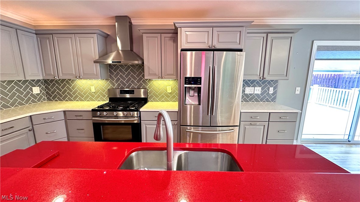 2603 Rockefeller Road Wickliffe, OH 44092 - Photo 6 of 34 Modern kitchen featuring a vibrant red countertop island with an undermount double-basin sink, stainless steel appliances including a gas range and French door refrigerator, light gray shaker-style cabinetry, and a gray herringbone tile backsplash