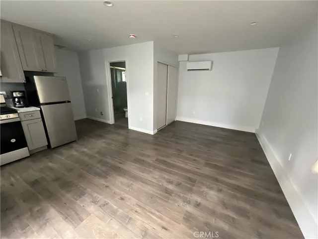 an empty room with wooden floor and a sink