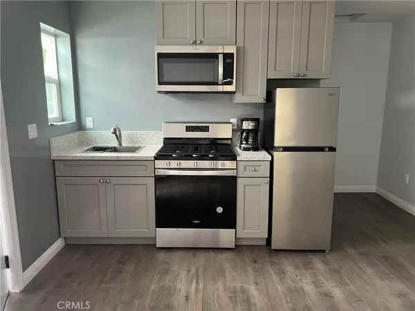 a kitchen with stainless steel appliances a stove a sink and a microwave