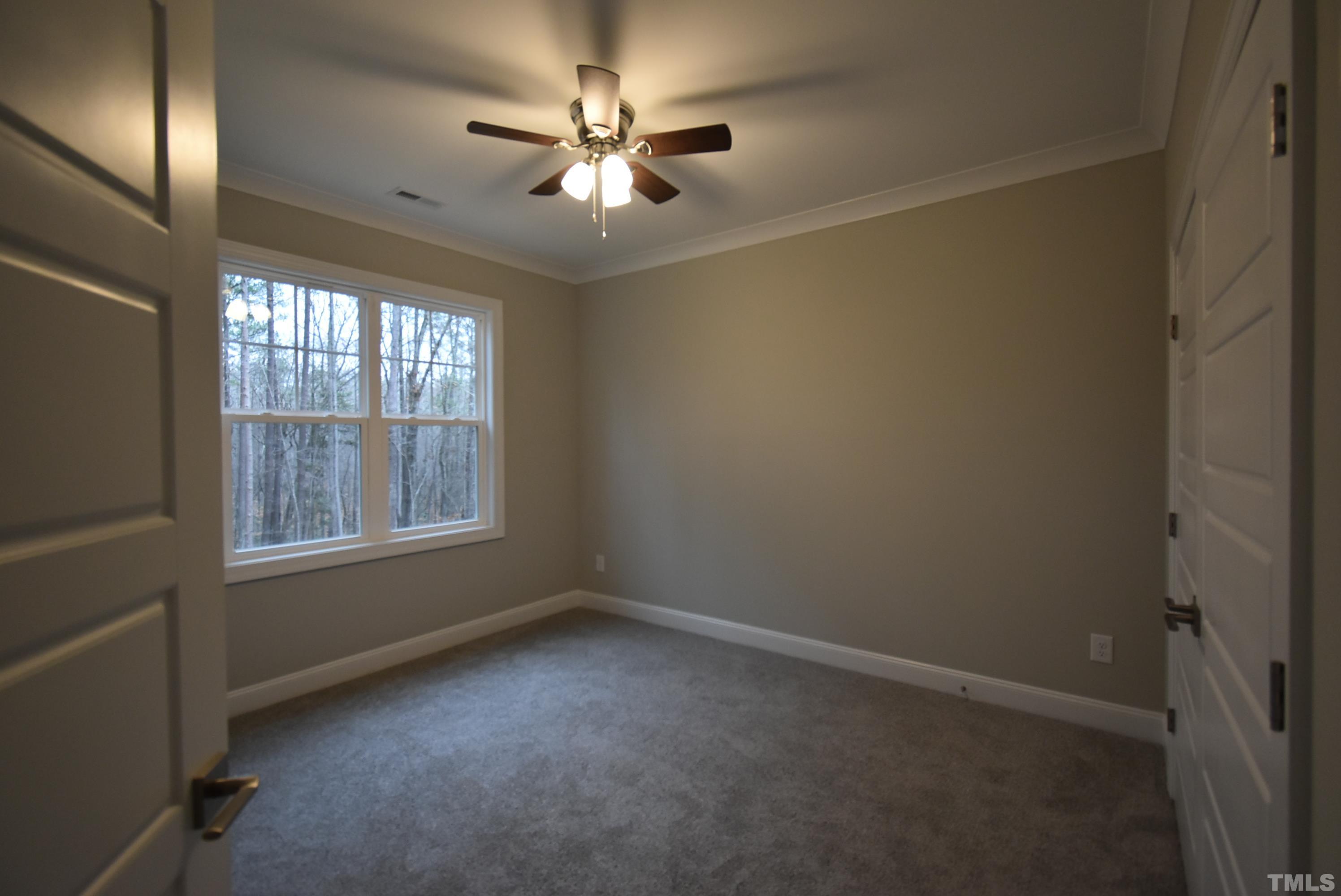 6237 Reagan Lane Wake Forest, NC 27587 - Photo 14 of 22 an empty room with a chandelier fan and windows
