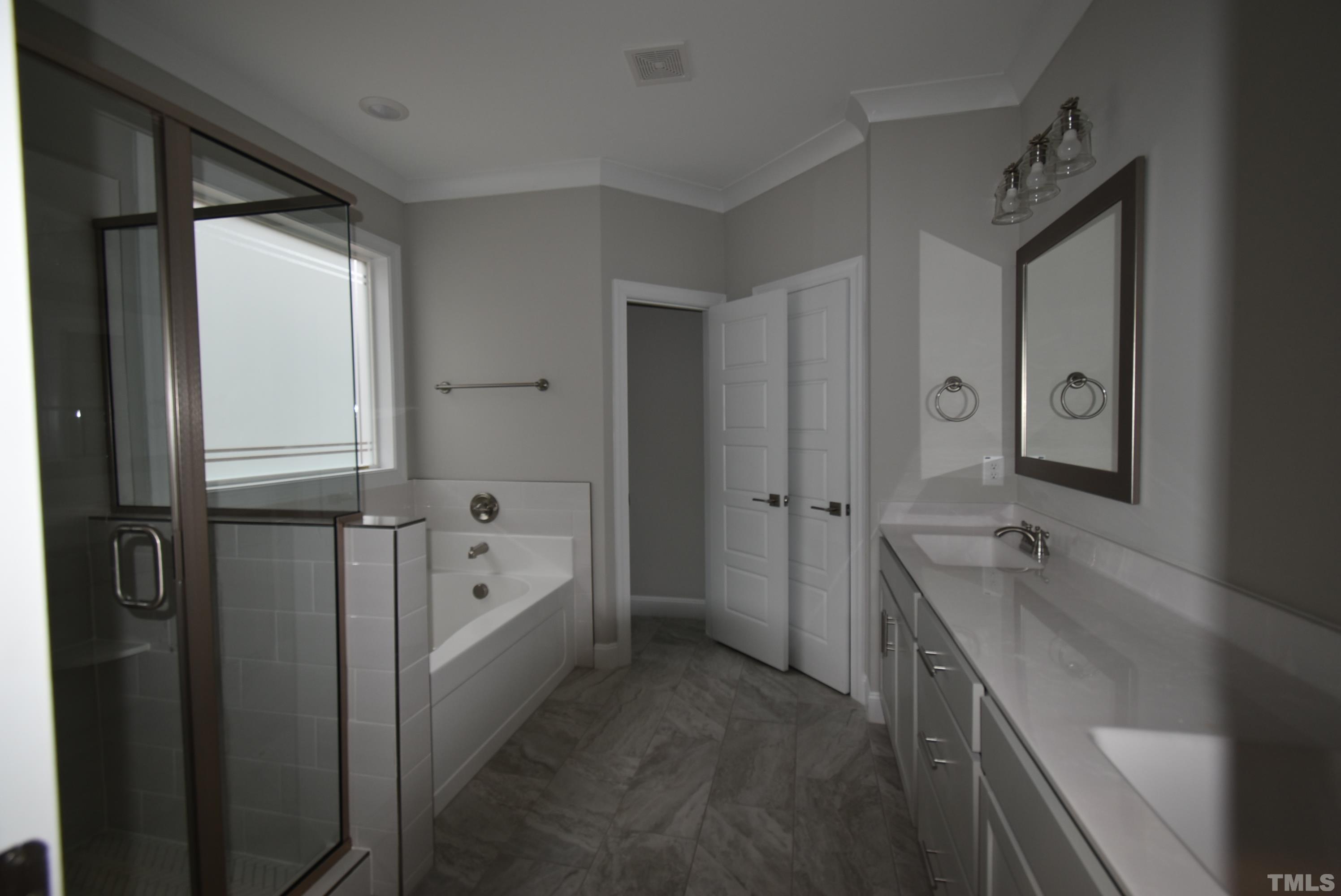 6237 Reagan Lane Wake Forest, NC 27587 - Photo 18 of 22 a bathroom with a tub a sink and a large mirror