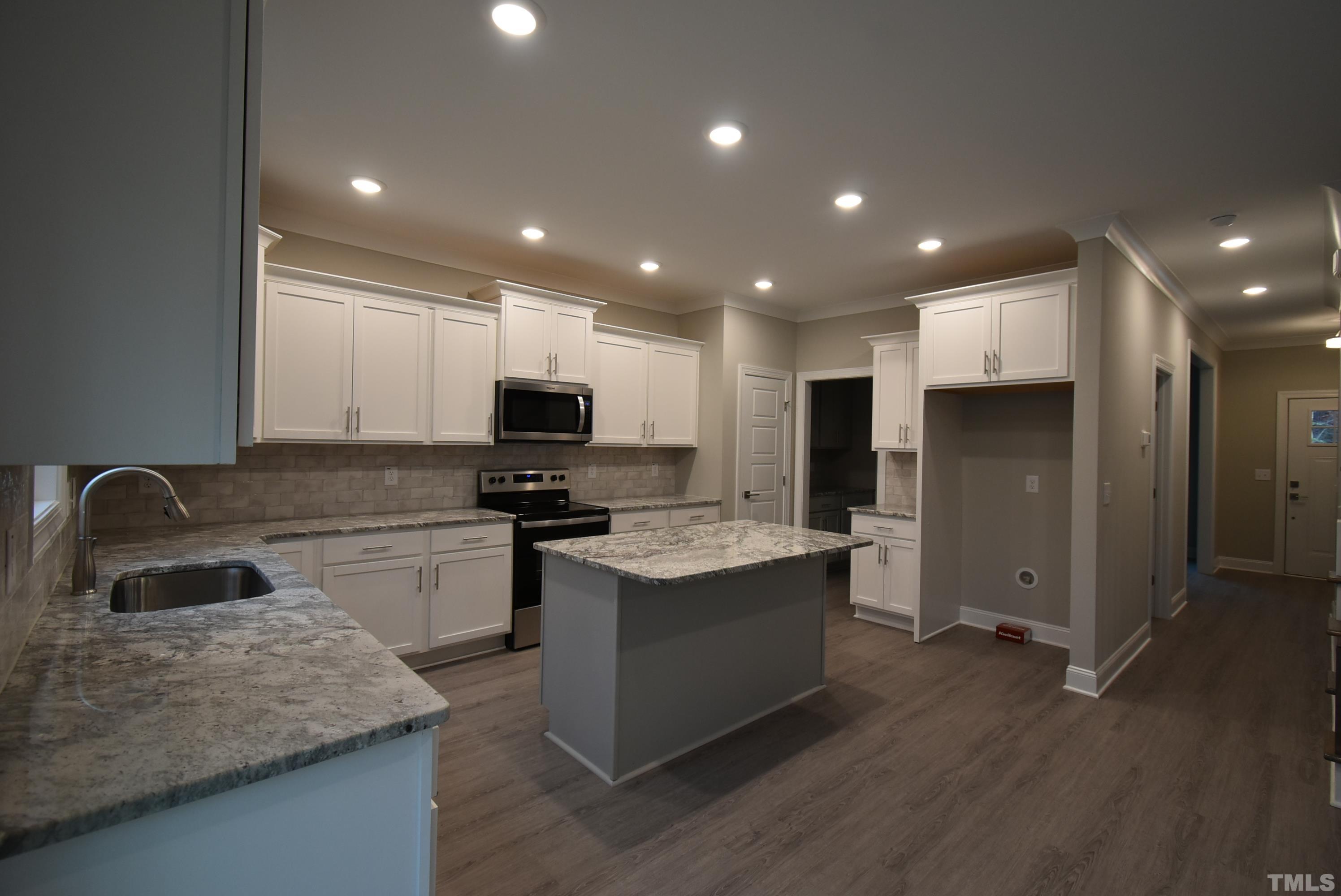 6237 Reagan Lane Wake Forest, NC 27587 - Photo 7 of 22 a kitchen with a sink stainless steel appliances and view living room