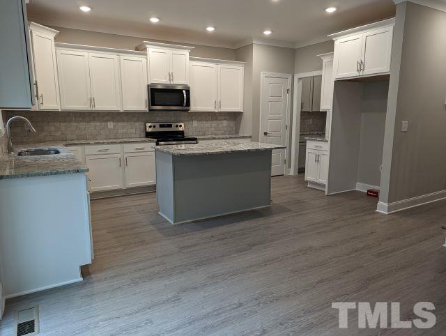 6237 Reagan Lane Wake Forest, NC 27587 - Photo 8 of 22 a kitchen with granite countertop a refrigerator and a stove top oven