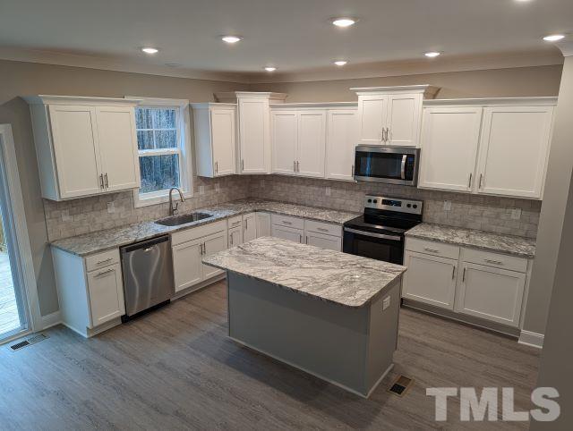6237 Reagan Lane Wake Forest, NC 27587 - Photo 9 of 22 a kitchen with kitchen island granite countertop stainless steel appliances sink stove microwave and cabinets