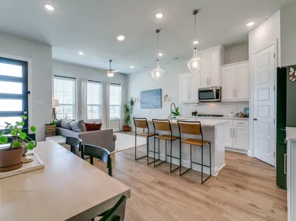 a kitchen with white cabinets and refrigerator
