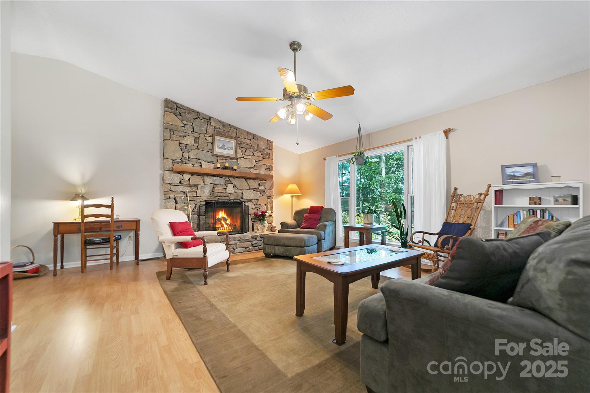 a living room with furniture a fireplace and a large window