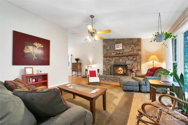 a living room with furniture a fireplace and a large window