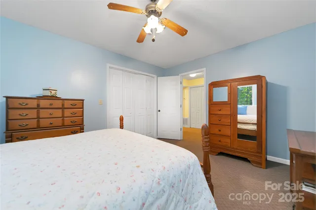 a bedroom with two beds and ceiling fan