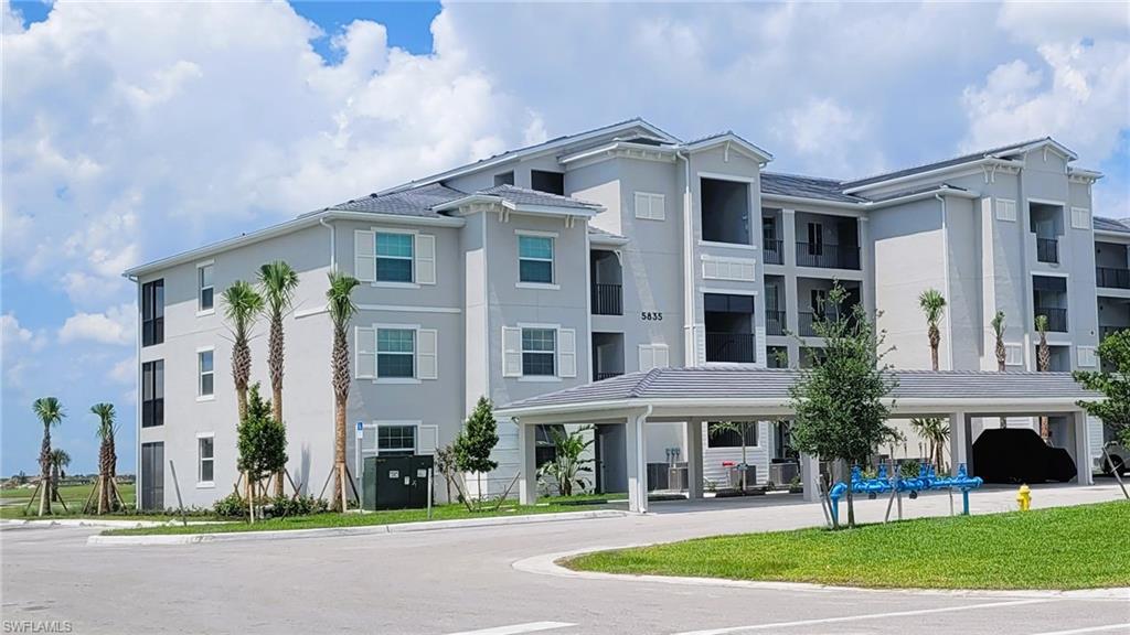 5835 Double Eagle Circle, Unit 4711 Immokalee, FL 34142 - Photo 25 of 44 a front view of a building with a yard