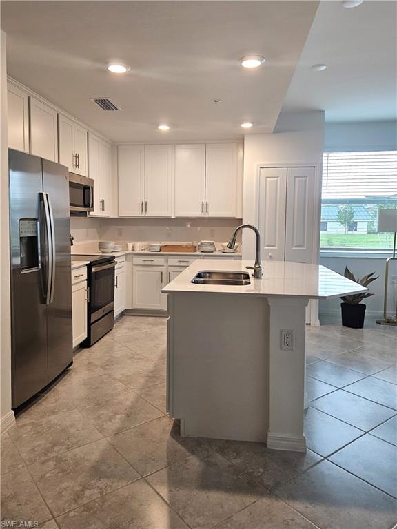 5835 Double Eagle Circle, Unit 4711 Immokalee, FL 34142 - Photo 5 of 44 a kitchen with kitchen island a sink stainless steel appliances and cabinets