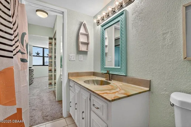 a bathroom with a sink a toilet and a mirror