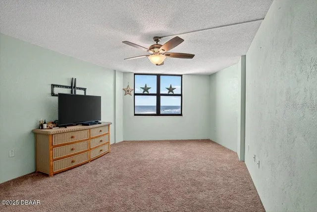 an empty room with windows and fireplace