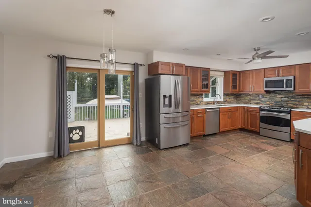 an empty room with wooden floor closet and windows