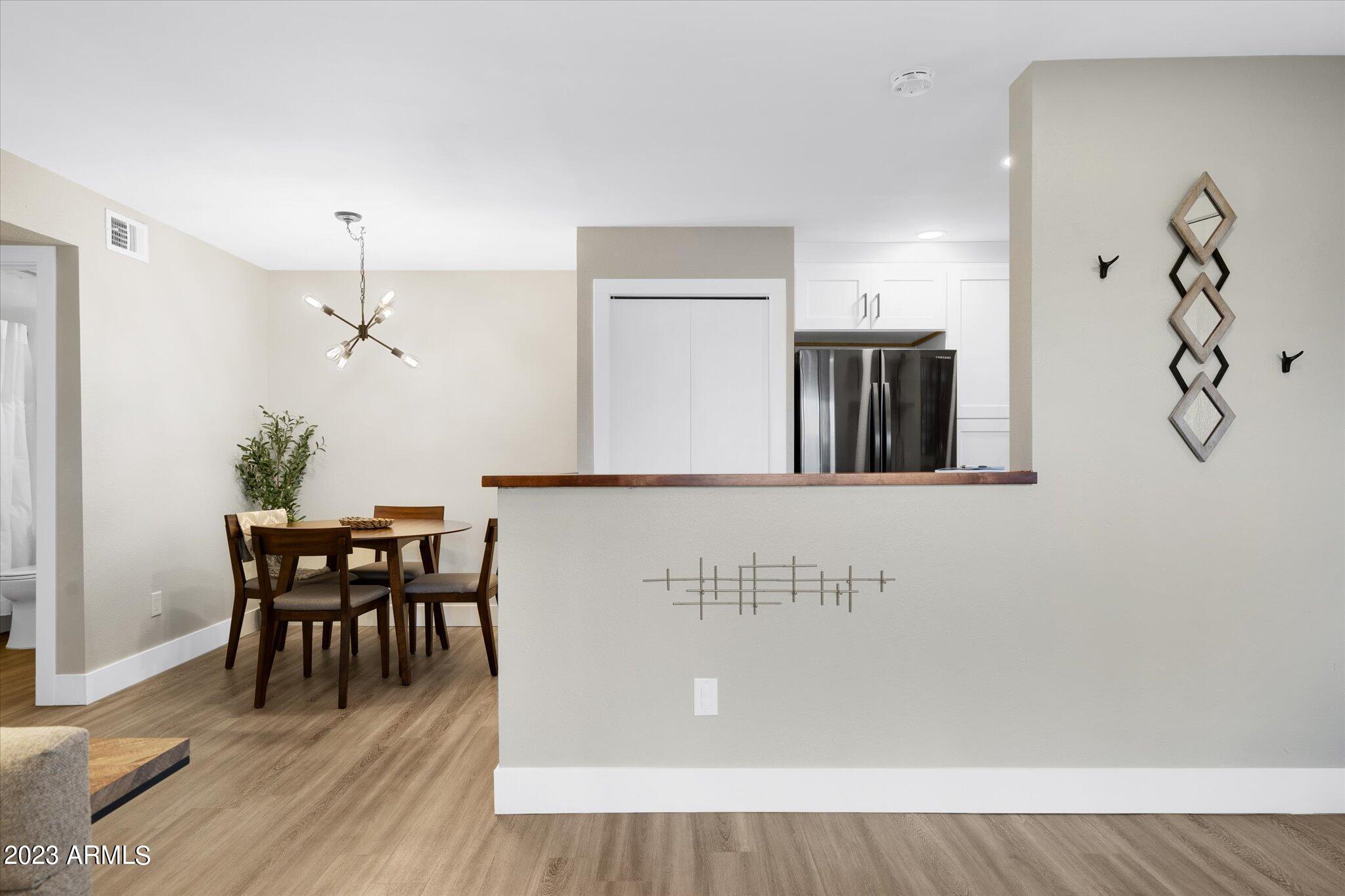 533 West Guadalupe Road, Unit 1024 Mesa, AZ 85210 - Photo 15 of 60 a view of a dining room with furniture and wooden floor