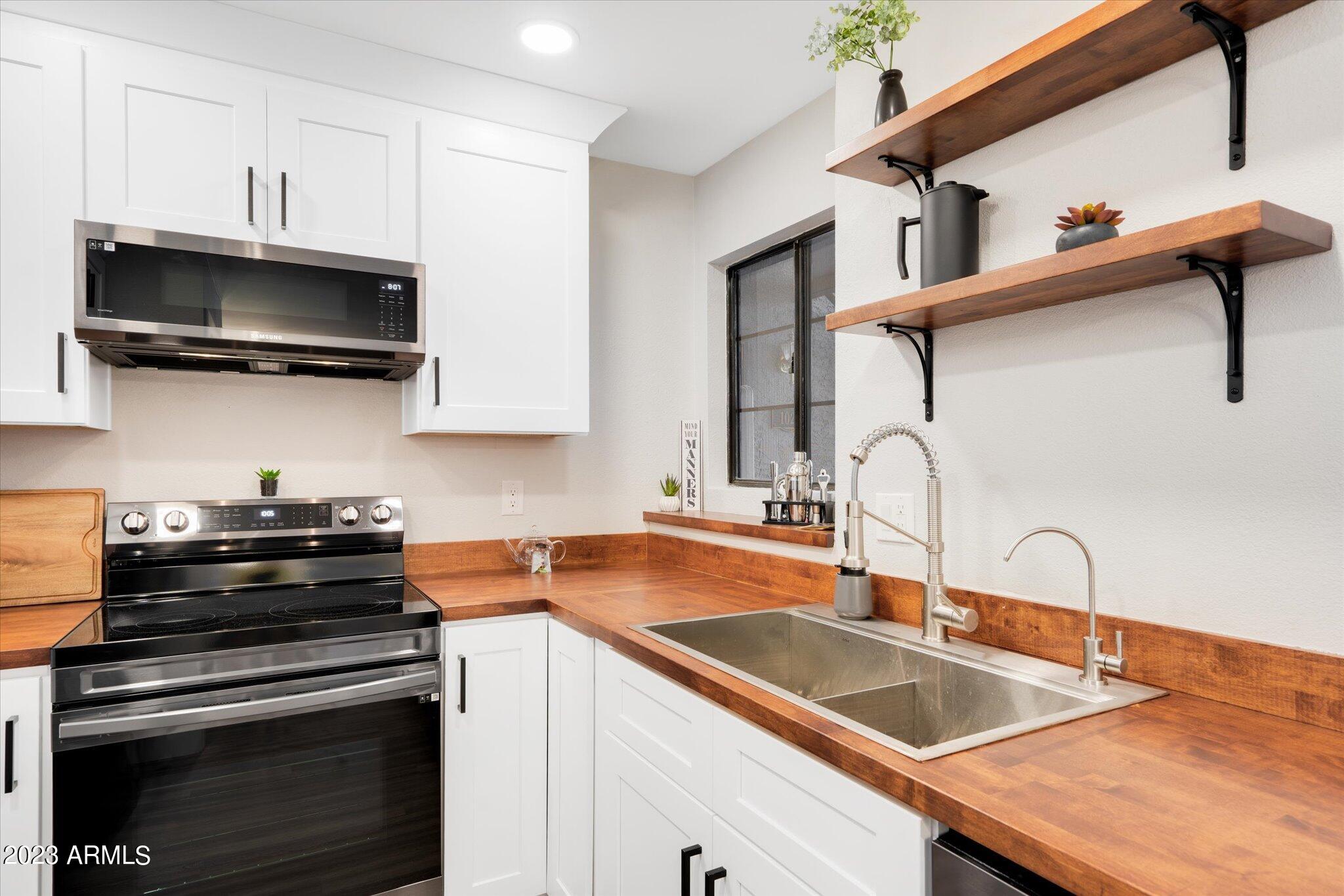 533 West Guadalupe Road, Unit 1024 Mesa, AZ 85210 - Photo 23 of 60 a kitchen with granite countertop a sink and a stove top oven