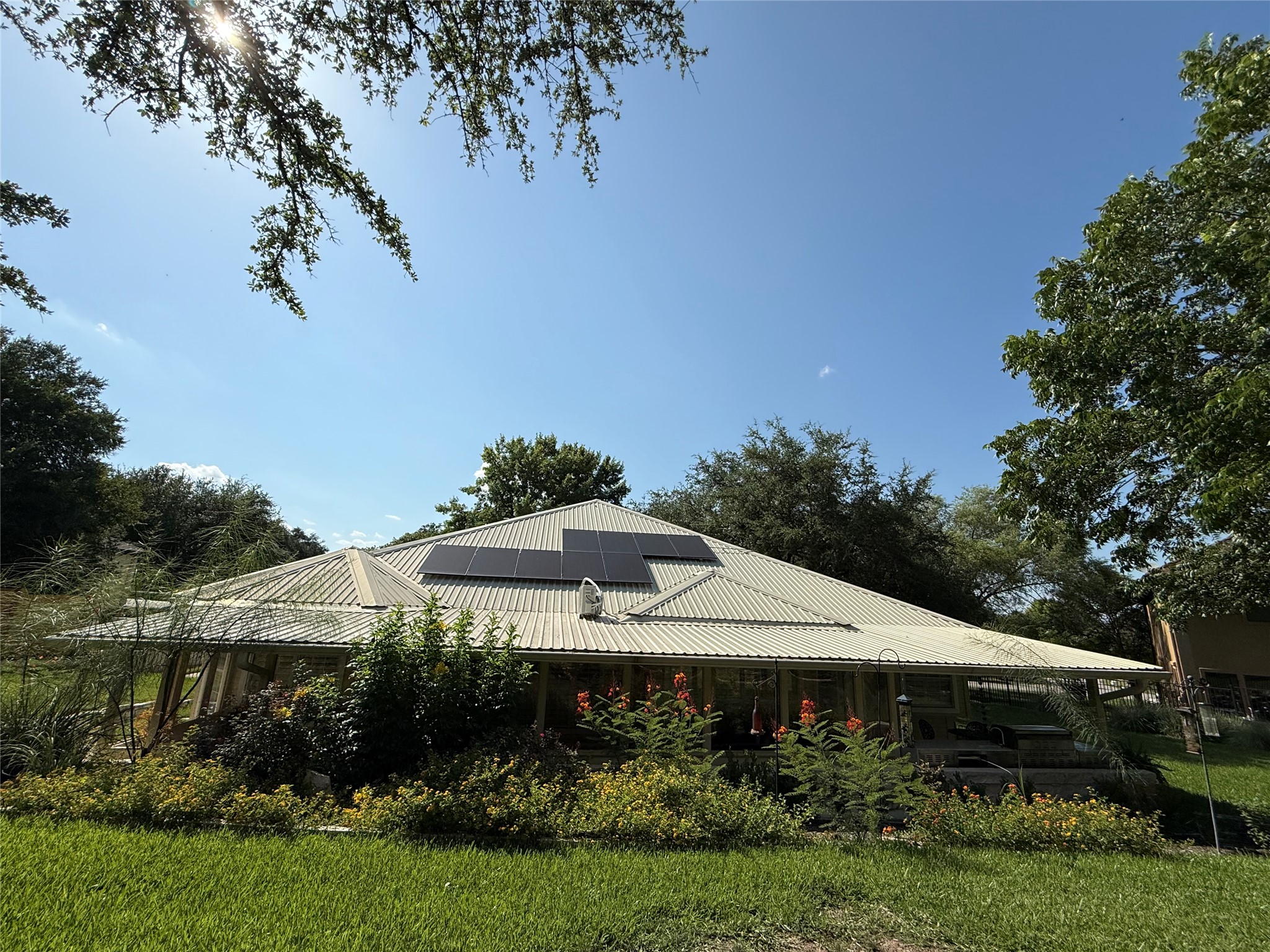 606 Explorer Lakeway, TX 78734 - Photo 20 of 29 View of home's exterior featuring roof mounted solar panels on the metal roof will be paid off by owner at closing! Incredible Garden provides Amazing, Floral View from Sunroom!