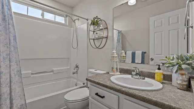 a bathroom with a granite countertop sink a toilet and a mirror