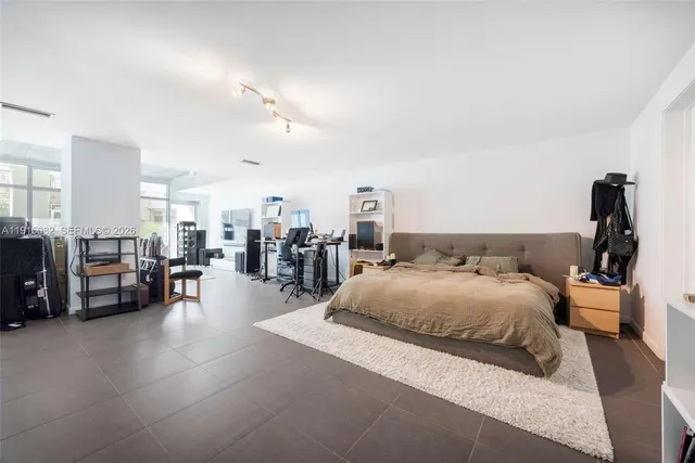 a spacious bedroom with a large bed and a view of living room