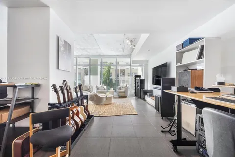 a large living room with stainless steel appliances granite countertop a couch and a large window