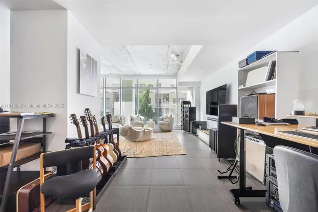 a large living room with stainless steel appliances granite countertop a couch and a large window