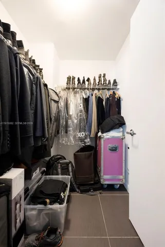 a view of walk in closet with clothes and shoes