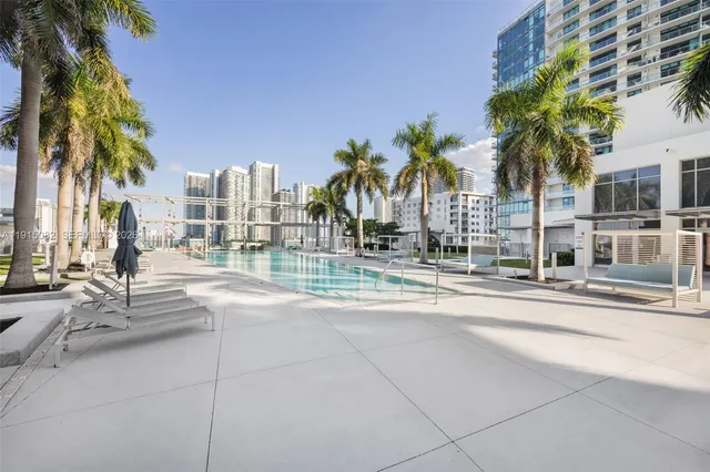 a row of palm trees and a building in the background