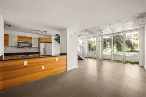 a view of a kitchen with a sink and dishwasher a refrigerator with white cabinets
