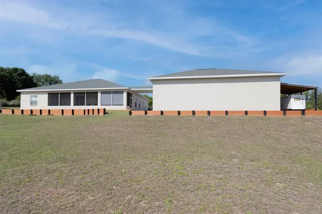a view of house with outdoor space and large tree