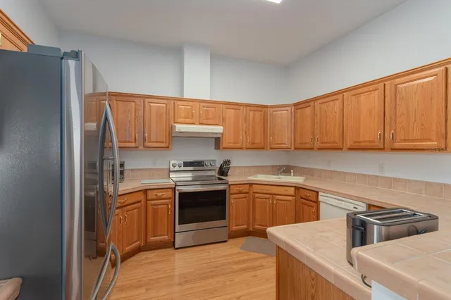 a kitchen with stainless steel appliances granite countertop a sink stove and refrigerator