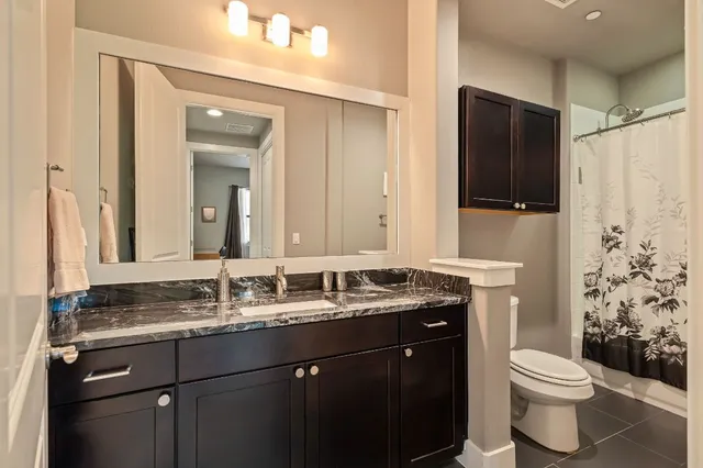 a bathroom with a granite countertop sink toilet and shower