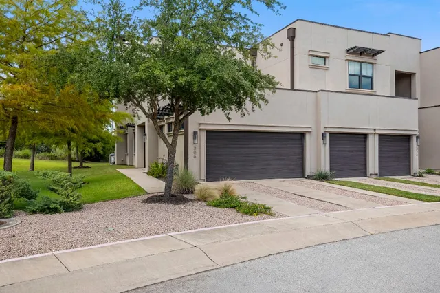 a front view of a house with a yard and a garage