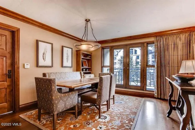 a dining room with furniture a chandelier and wooden floor