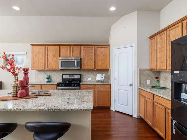 a kitchen with stainless steel appliances granite countertop a refrigerator sink and stove